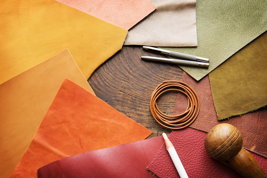 Leather craft. Colorful pieces of beautifully colored or tanned Leather craft. Colorful pieces of beautifully colored or tanned leather and leather working tools on leather craftman's work desk .